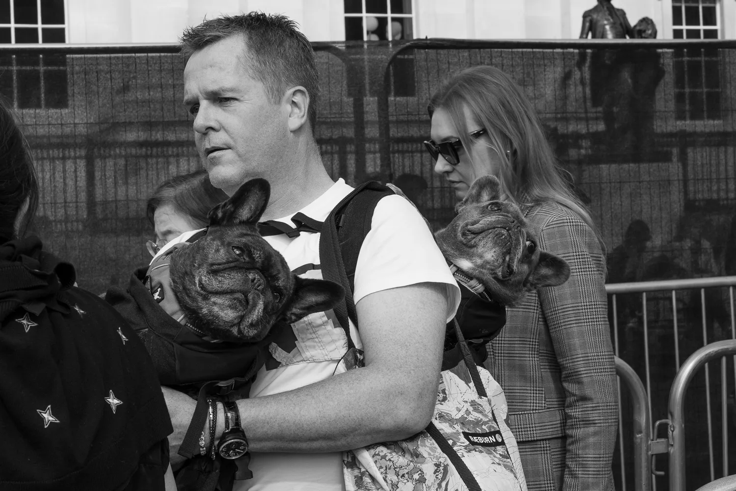 A man carrying dogs on his front and back