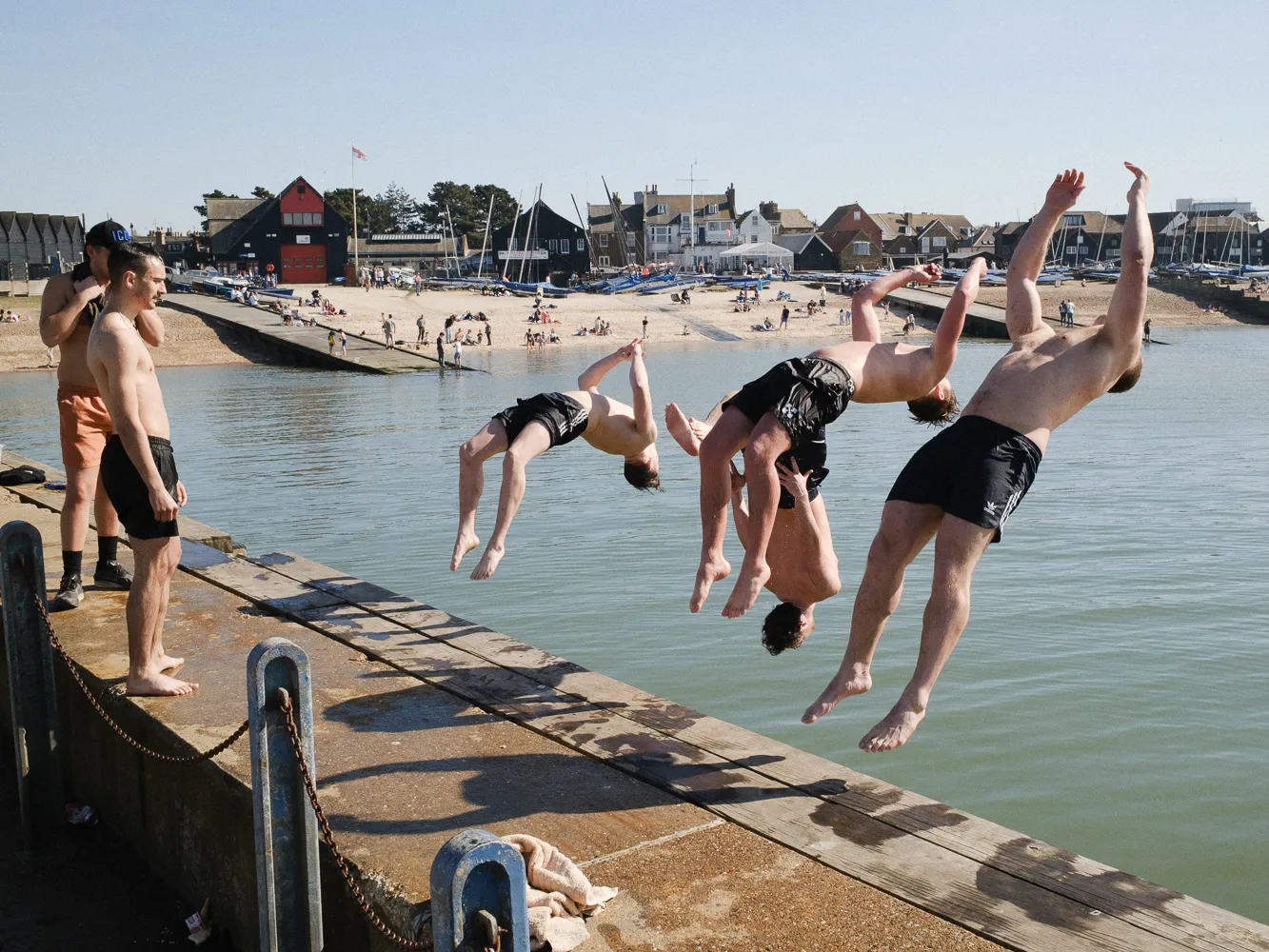 Swimmers leaping from a harbour wall into the water