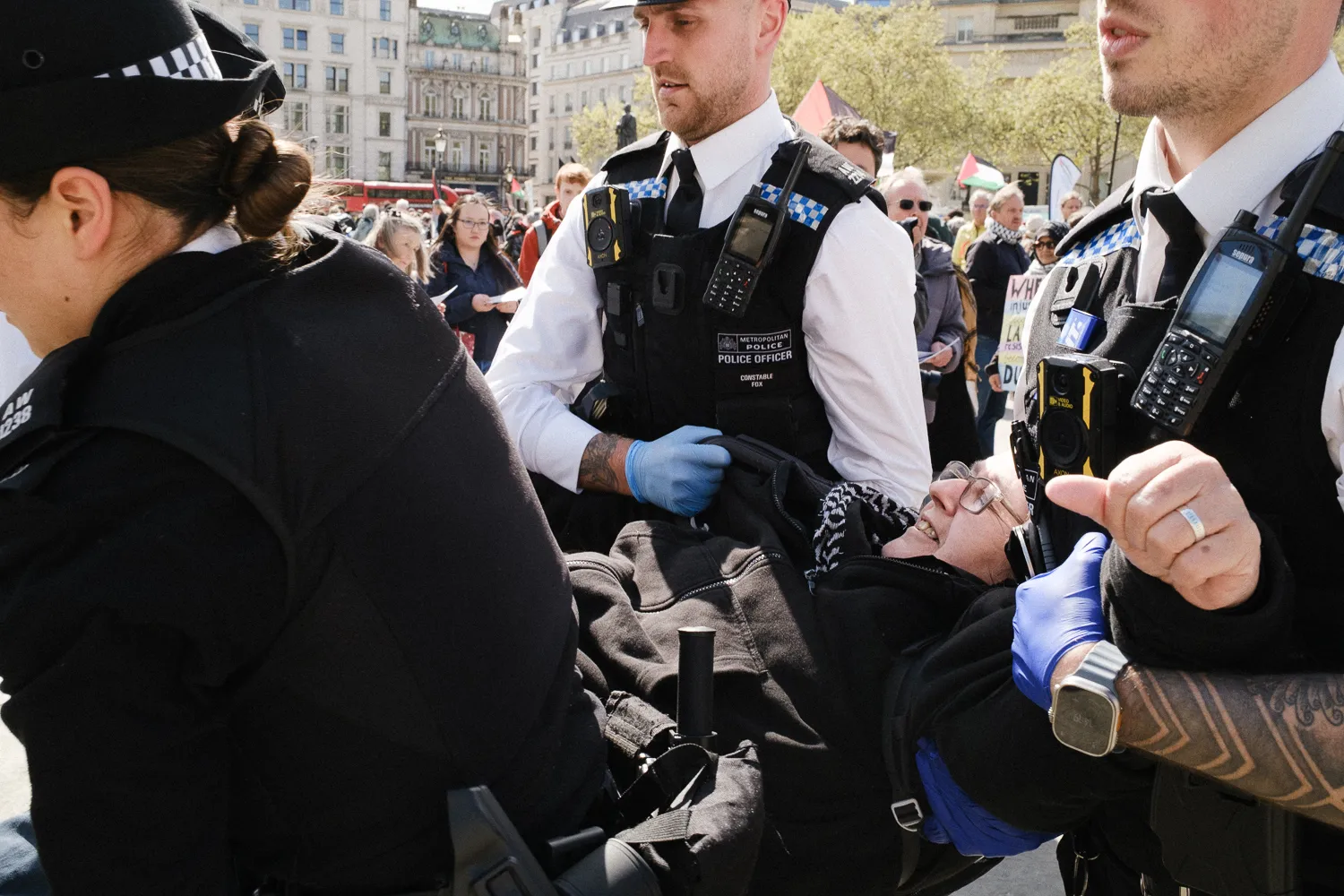 Police officers carrying a person in a crowd