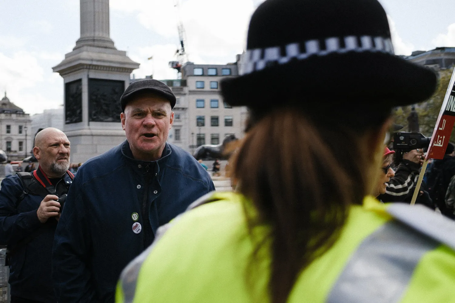 A man shouting at a police officer in Trafalgar Square