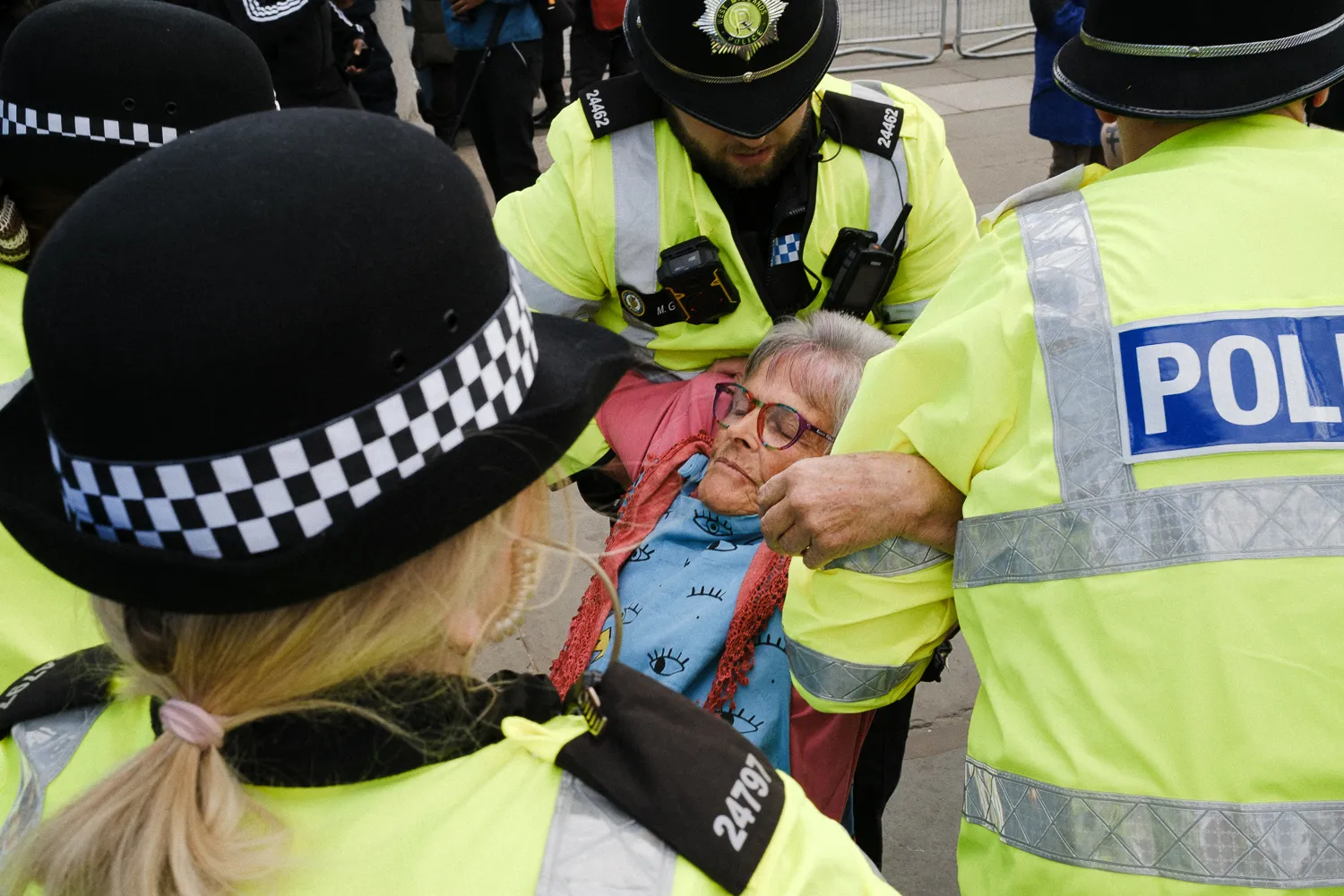 A close view of police officers carrying an old woman