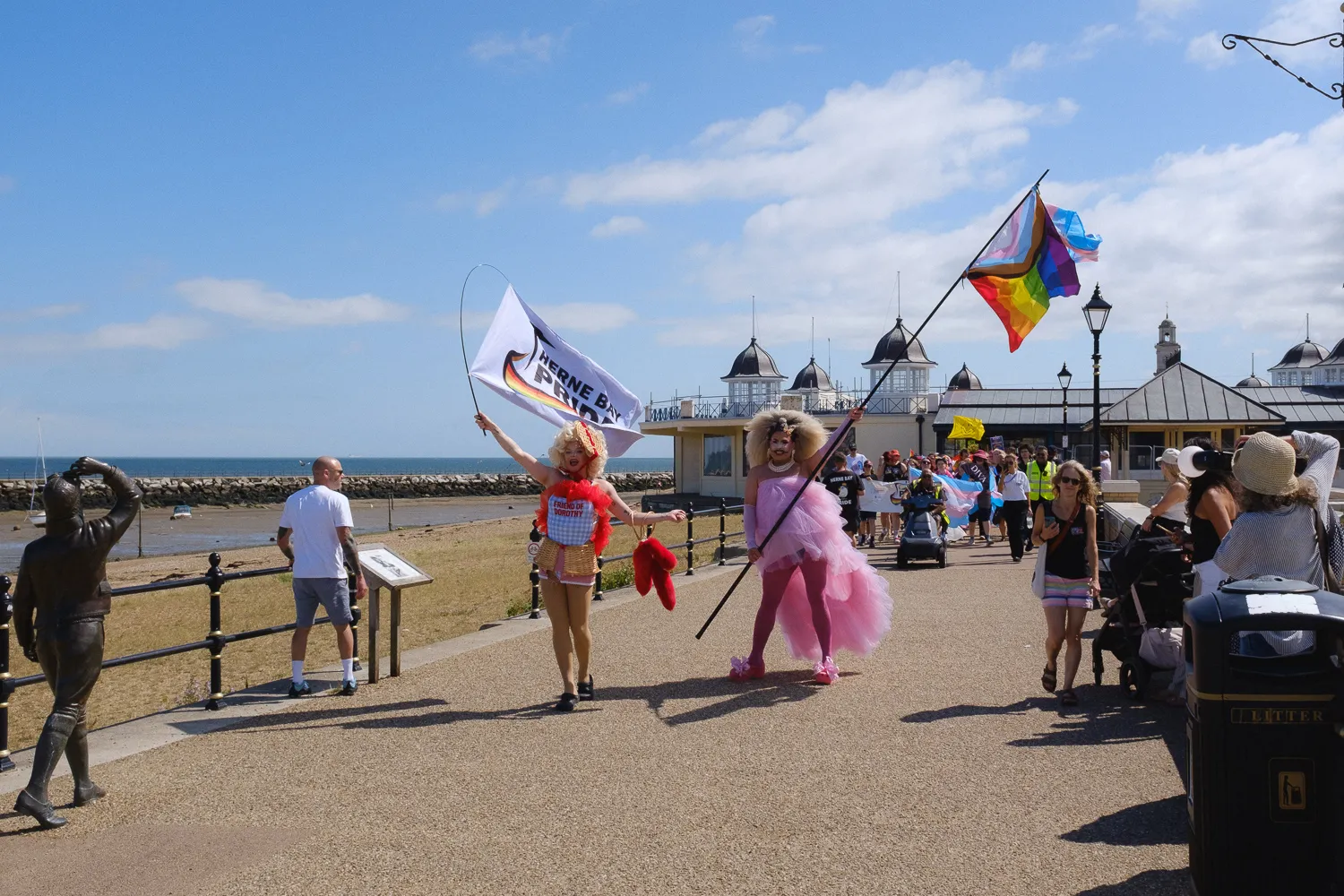 Herne Bay Pride participants carrying flags along the promenade